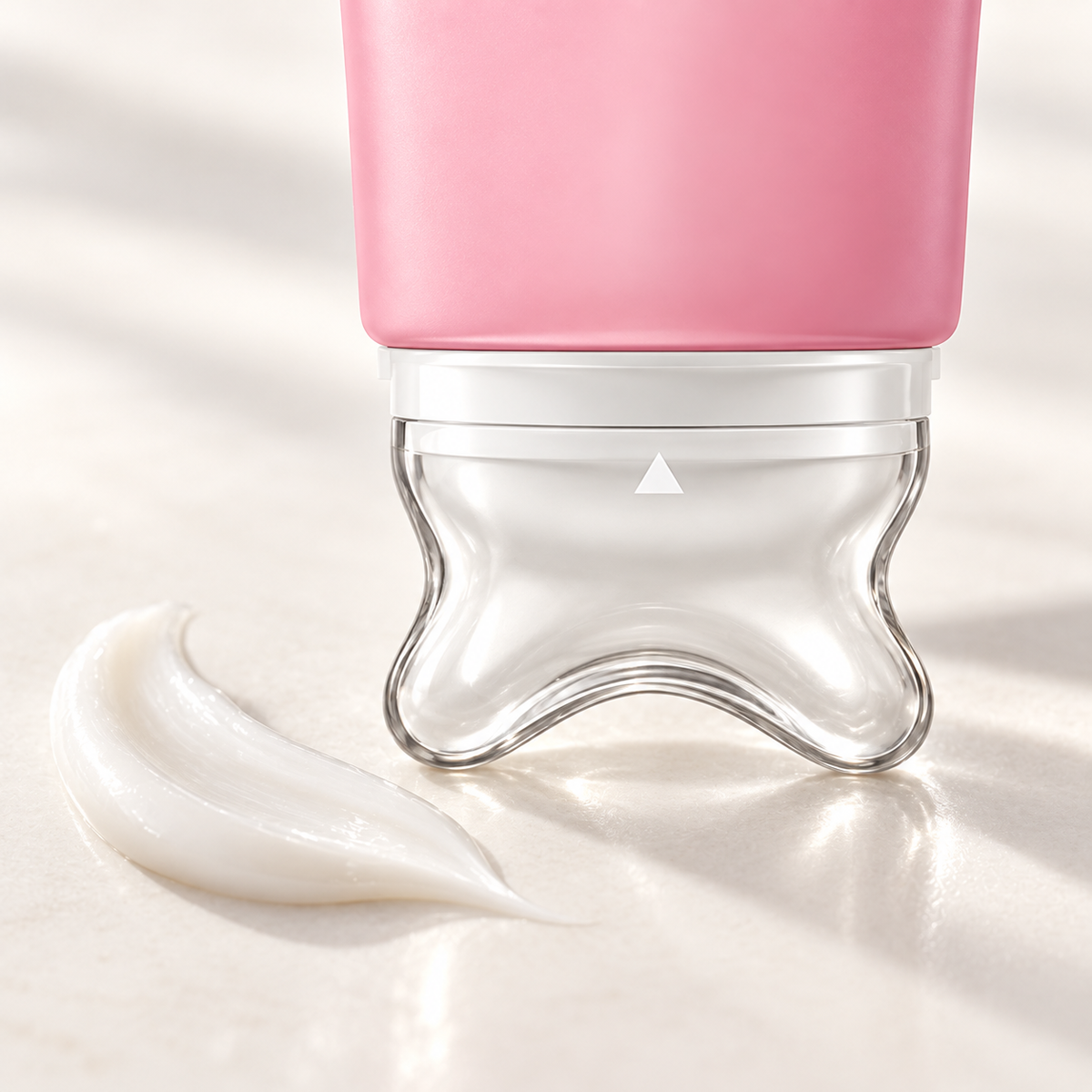 Close-up of NeckSilk curved massage applicator beside lightweight cream texture